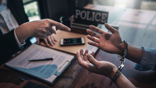 Midsection of woman using mobile phone on table