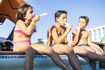 Friends sitting in swimming pool