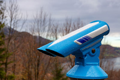 Close-up of coin-operated binoculars against sky