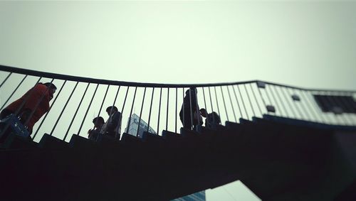 Low angle view of people standing on ladder