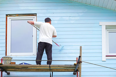 Rear view of man standing against building