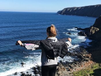 Rear view of woman looking at sea against sky