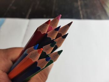 Close-up of hand holding colored pencils