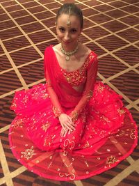 Portrait of a smiling young woman sitting on floor