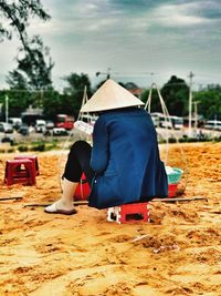 Rear view of woman wearing hat on land against sky