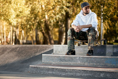 Man wearing cap sitting on staircase