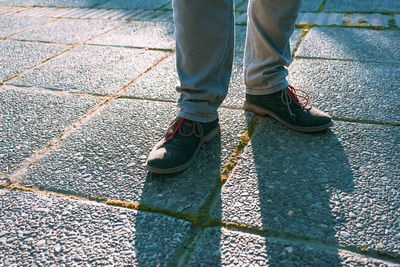 Low section of man standing on footpath