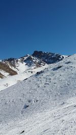 Scenic view of snowcapped mountains against clear blue sky