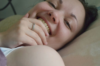 Portrait of happy woman lying on bed at home