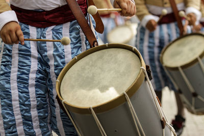 Midsection of men playing drums