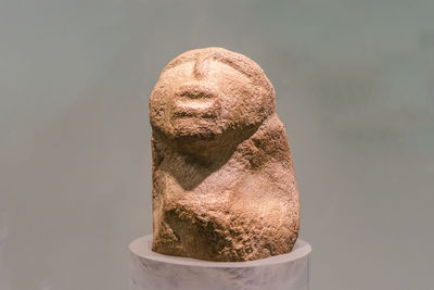 Close-up of statue on table against gray background