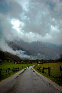 Road leading towards mountains against sky