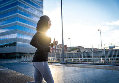 Man standing against buildings in city against sky