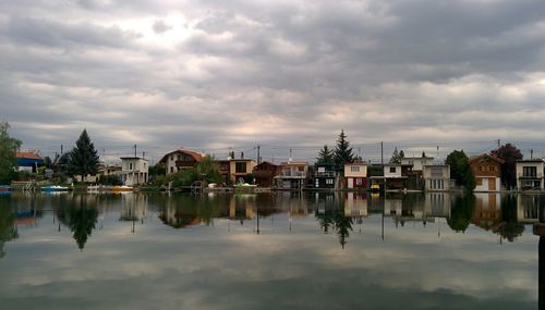 Reflection of buildings in lake against sky