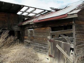 Close-up of abandoned barn against sky