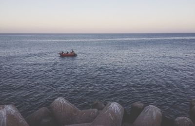 Boat in calm blue sea against clear sky