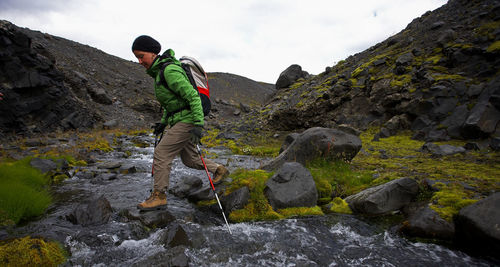 Woman crossing small stream on the laugavegur hiking trail