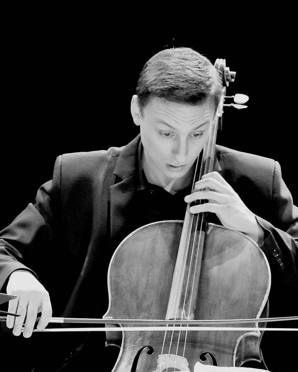 musical instrument, music, arts culture and entertainment, one person, playing, string instrument, musician, musical equipment, performance, artist, cello, real people, front view, skill, young men, men, concentration, indoors, black background, cellist, bow - musical equipment, stage