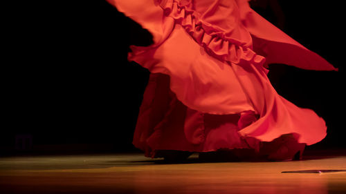 Low section of dancer in red costume performing on stage
