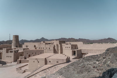 Buildings in desert against clear sky