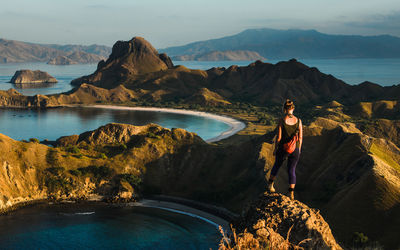 Woman standing on rock looking at mountains