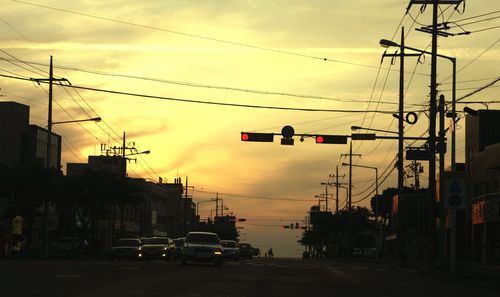 Cars on road against cloudy sky