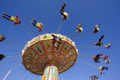 Low angle view of chain swing ride against sky