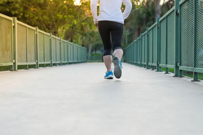 Rear view of woman standing on footbridge