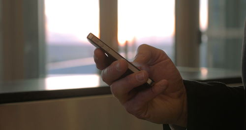 Midsection of man using mobile phone