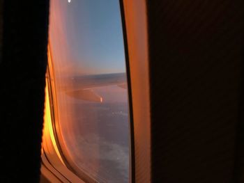 Close-up of airplane window against sky at night