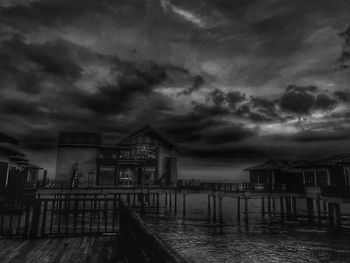 Houses by sea against sky at dusk