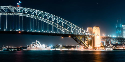 Illuminated bridge over river at night