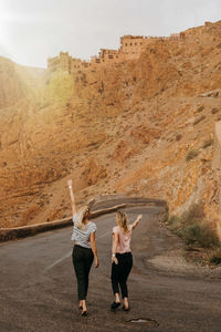 Rear view of people walking on road