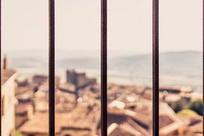 Close-up of bars against buildings in city