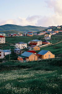 Houses on field against sky in city