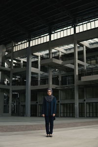 Portrait of young man standing in building