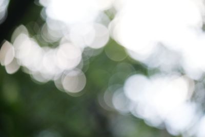 Defocused image of illuminated lights against sky