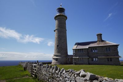 Lighthouse by sea against sky