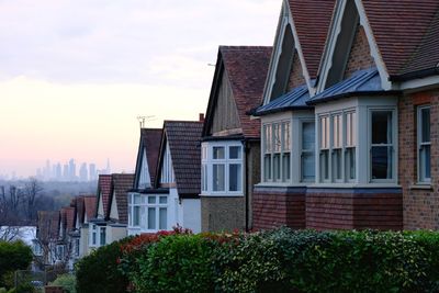 Low angle view of houses against city skyline 