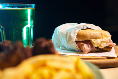 Close-up of sandwich on a table ready to be eat with a fresh beer