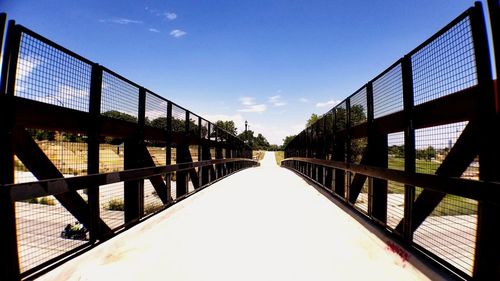 Empty footbridge against clear sky