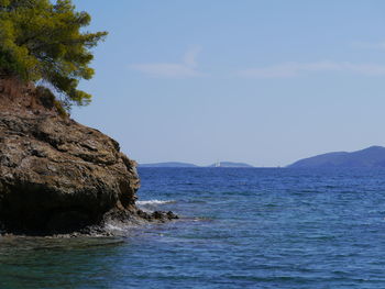 Rock formation in sea against blue sky