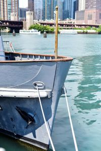 Sailboats moored on river in city