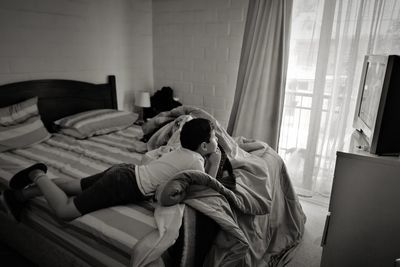 High angle view of boy relaxing on bed at home