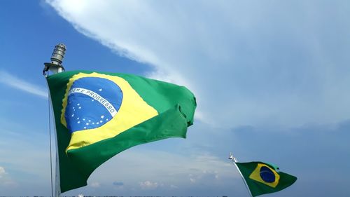 Low angle view of brazilian flag against cloudy sky