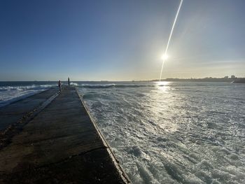 Scenic view of sea against bright sun