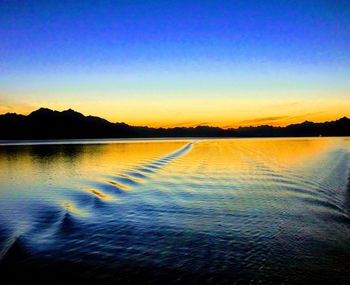 Scenic view of lake against clear sky at sunset