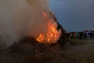 People standing at bonfire during dusk