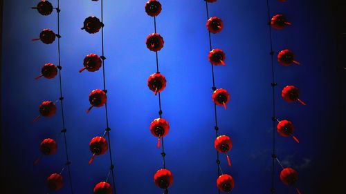 Low angle view of red lanterns hanging against sky