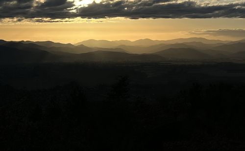 Scenic view of silhouette mountains against sky during sunset